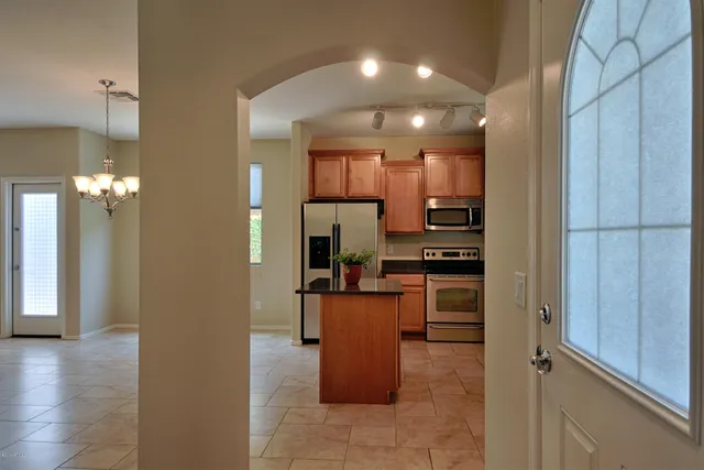 a kitchen with a refrigerator and a stove top oven