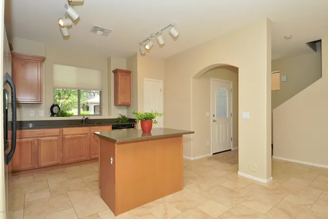 a kitchen with granite countertop a sink stove and cabinets