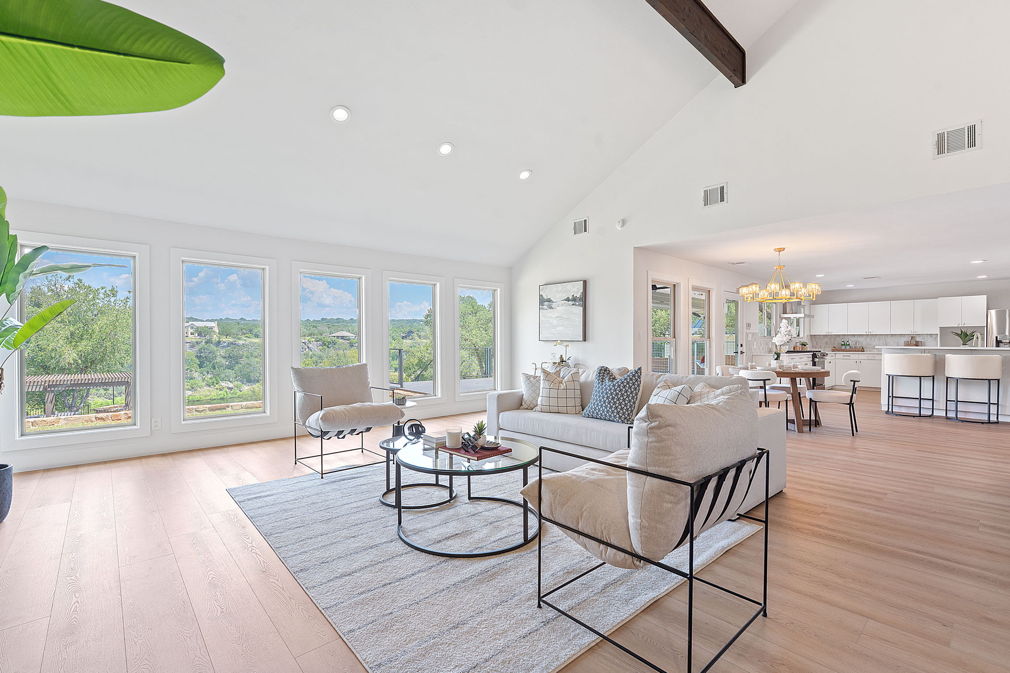 1325 Likeness Road Spicewood, TX 78669 - Photo 13 of 40 Living area with light wood finished floors, vaulted ceiling, a chandelier, and healthy amount of natural light
