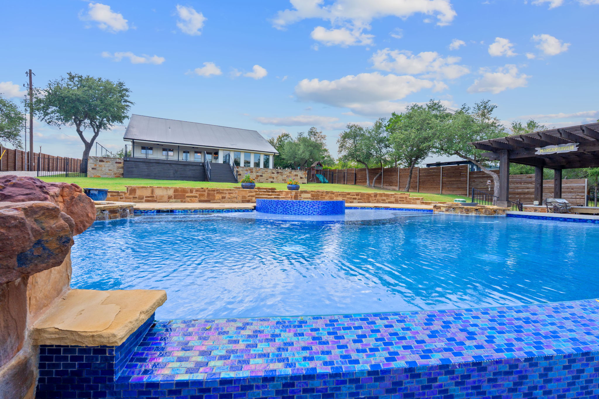 1325 Likeness Road Spicewood, TX 78669 - Photo 27 of 40 View of swimming pool with a pergola, a fenced backyard, and patio surround