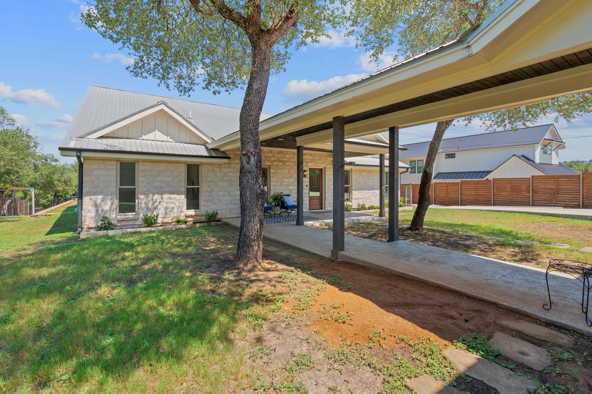 1325 Likeness Road Spicewood, TX 78669 - Photo 9 of 40 View of front facade with a patio, board and batten siding, and a metal roof