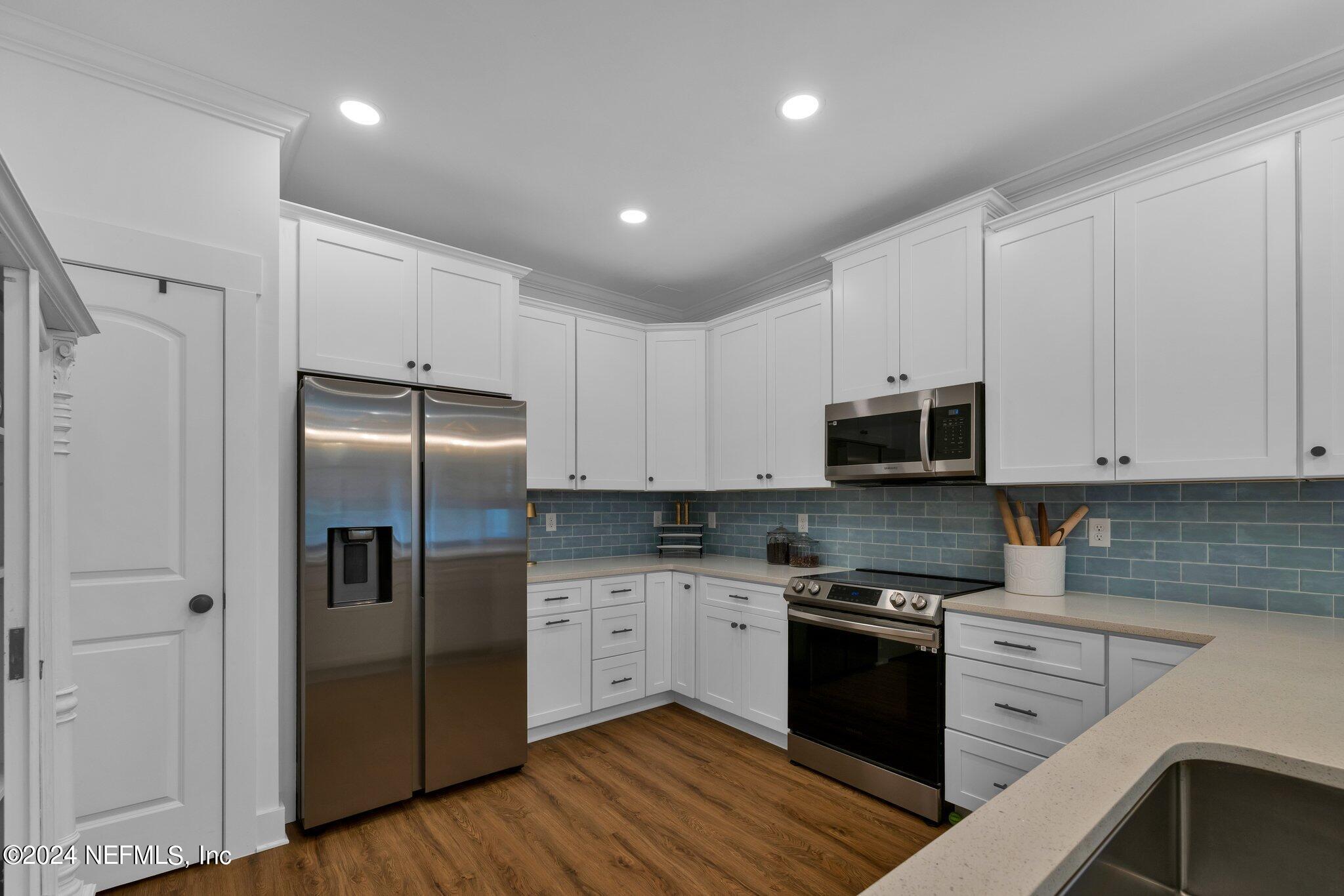 6825 A Ave Street St. Augustine, FL 32080 - Photo 44 of 53 a kitchen with stainless steel appliances and white cabinets