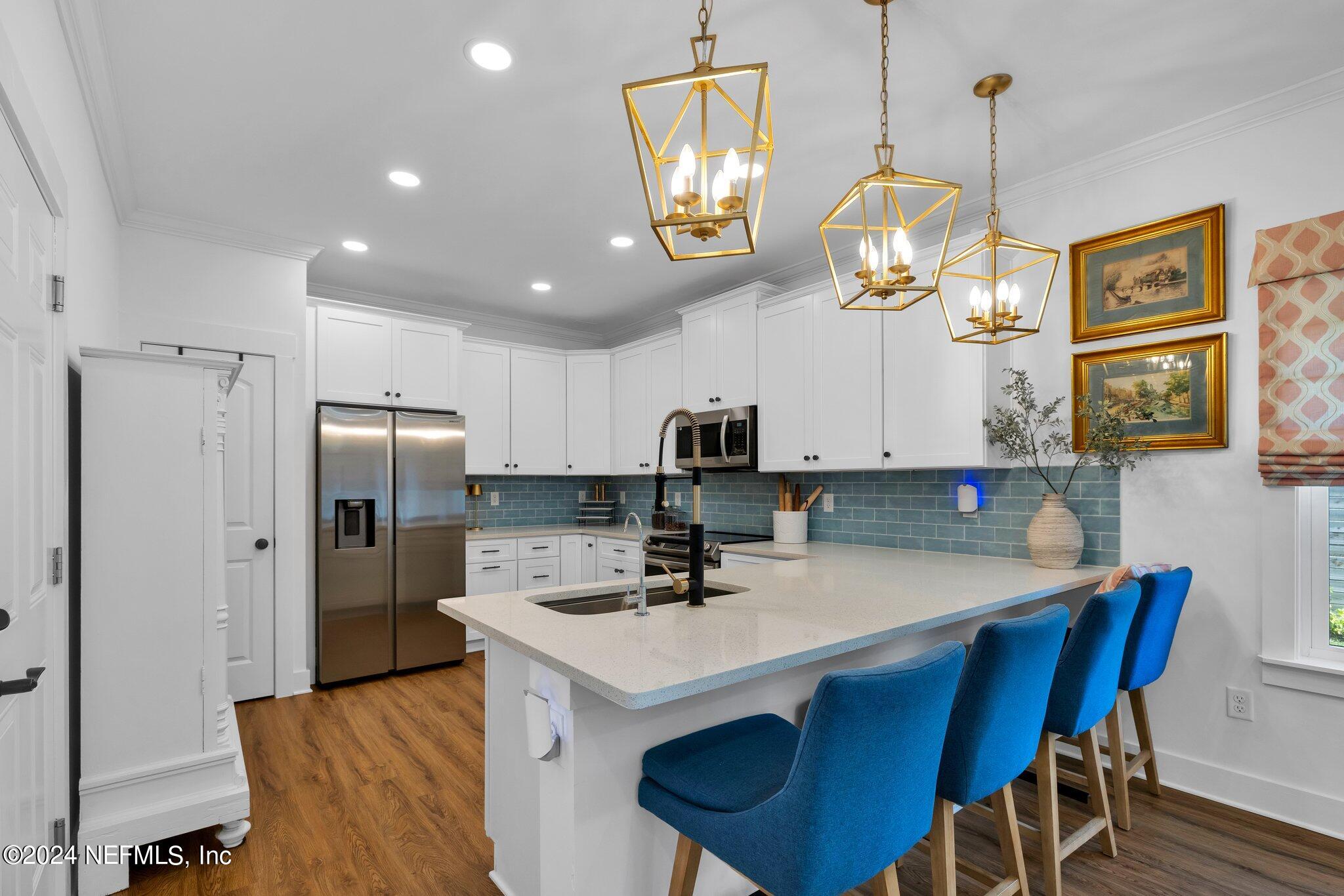 6825 A Ave Street St. Augustine, FL 32080 - Photo 49 of 53 a kitchen with stainless steel appliances a sink a refrigerator a stove a microwave oven a table and chairs