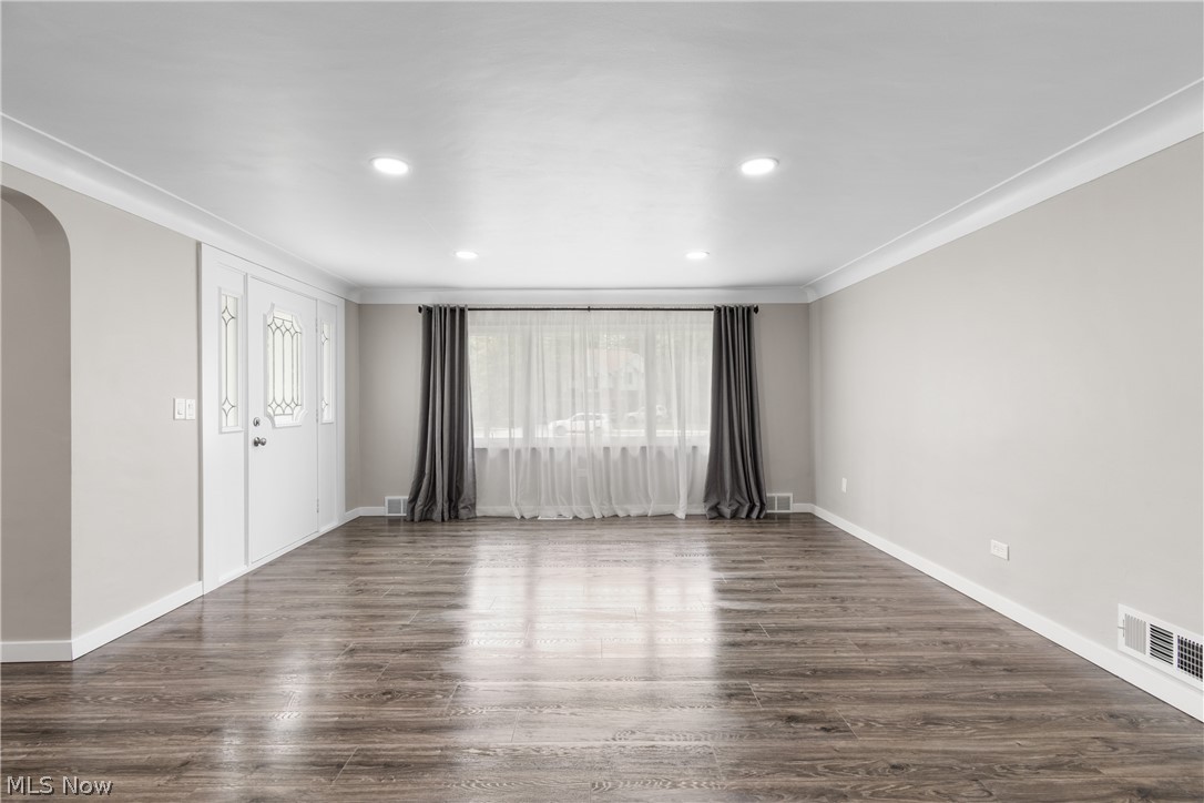 10876 West Sprague Road Cleveland, OH 44130 - Photo 13 of 31 Empty room featuring a healthy amount of sunlight, dark hardwood / wood-style floors, and crown molding