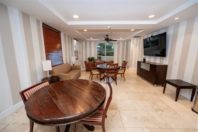 a dining room with furniture and a floor to ceiling window