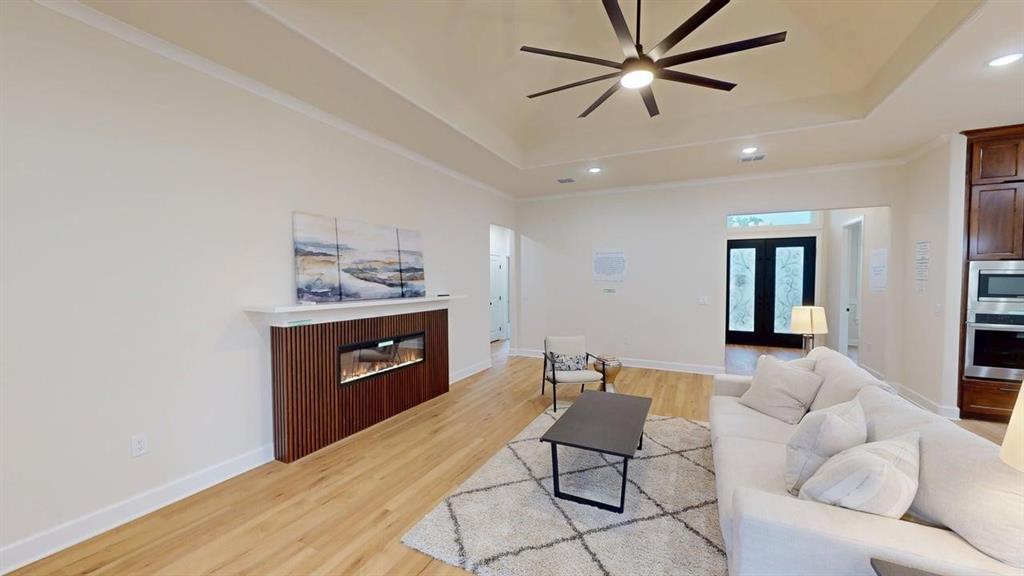 2509 Windmill Lane Longview, TX 75601 - Photo 2 of 35 Living area featuring a raised ceiling, a ceiling fan, recessed lighting, light wood finished floors, and a glass covered fireplace