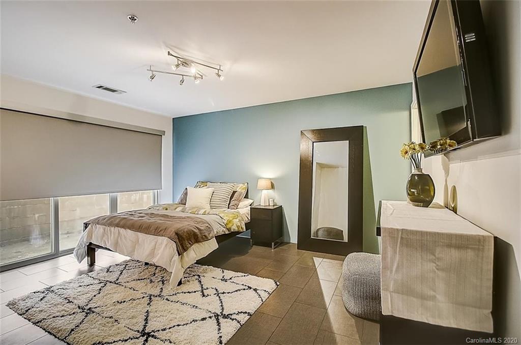 652 Raphael Place Charlotte, NC 28205 - Photo 15 of 26 a bedroom with a bed and a flat tv screen on dresser