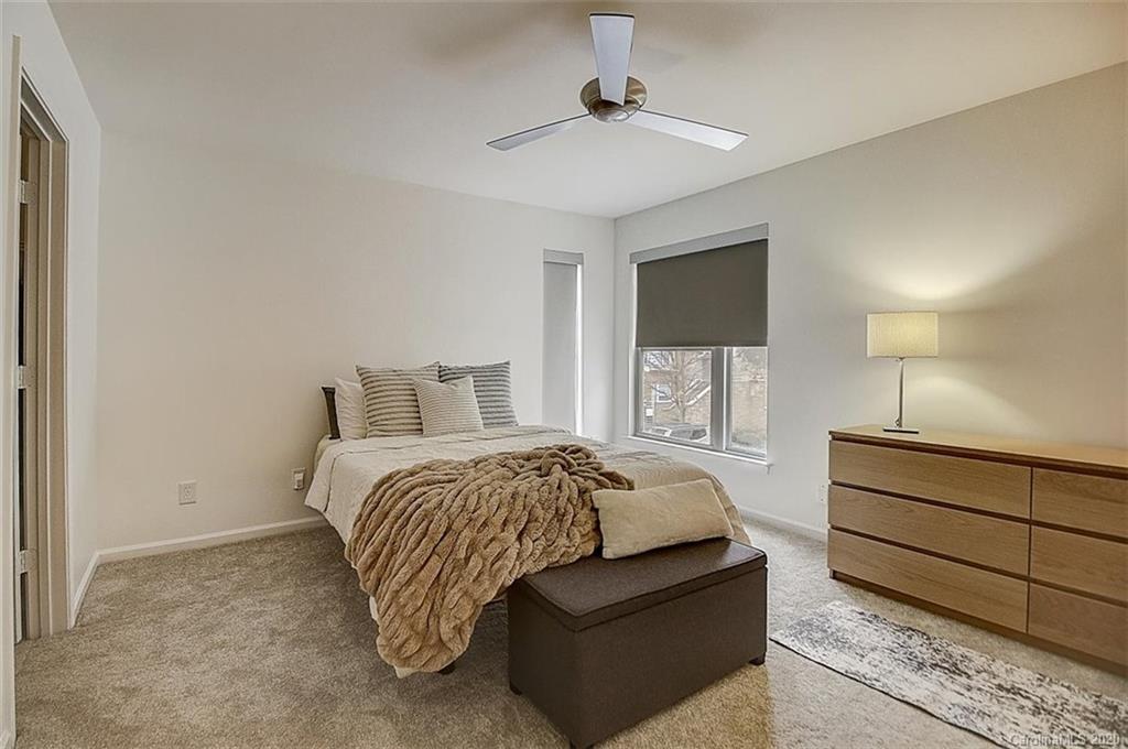 652 Raphael Place Charlotte, NC 28205 - Photo 9 of 26 a bedroom with a bed and a chandelier