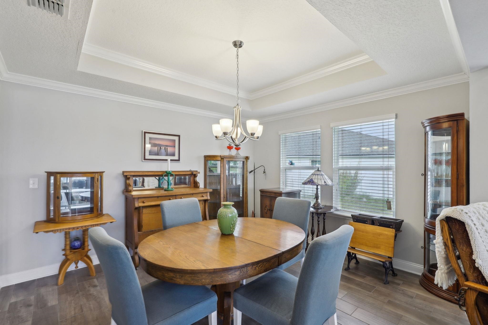 443 Sweet Mango Trail St. Augustine, FL 32086 - Photo 13 of 54 a dining room with furniture a chandelier and wooden floor