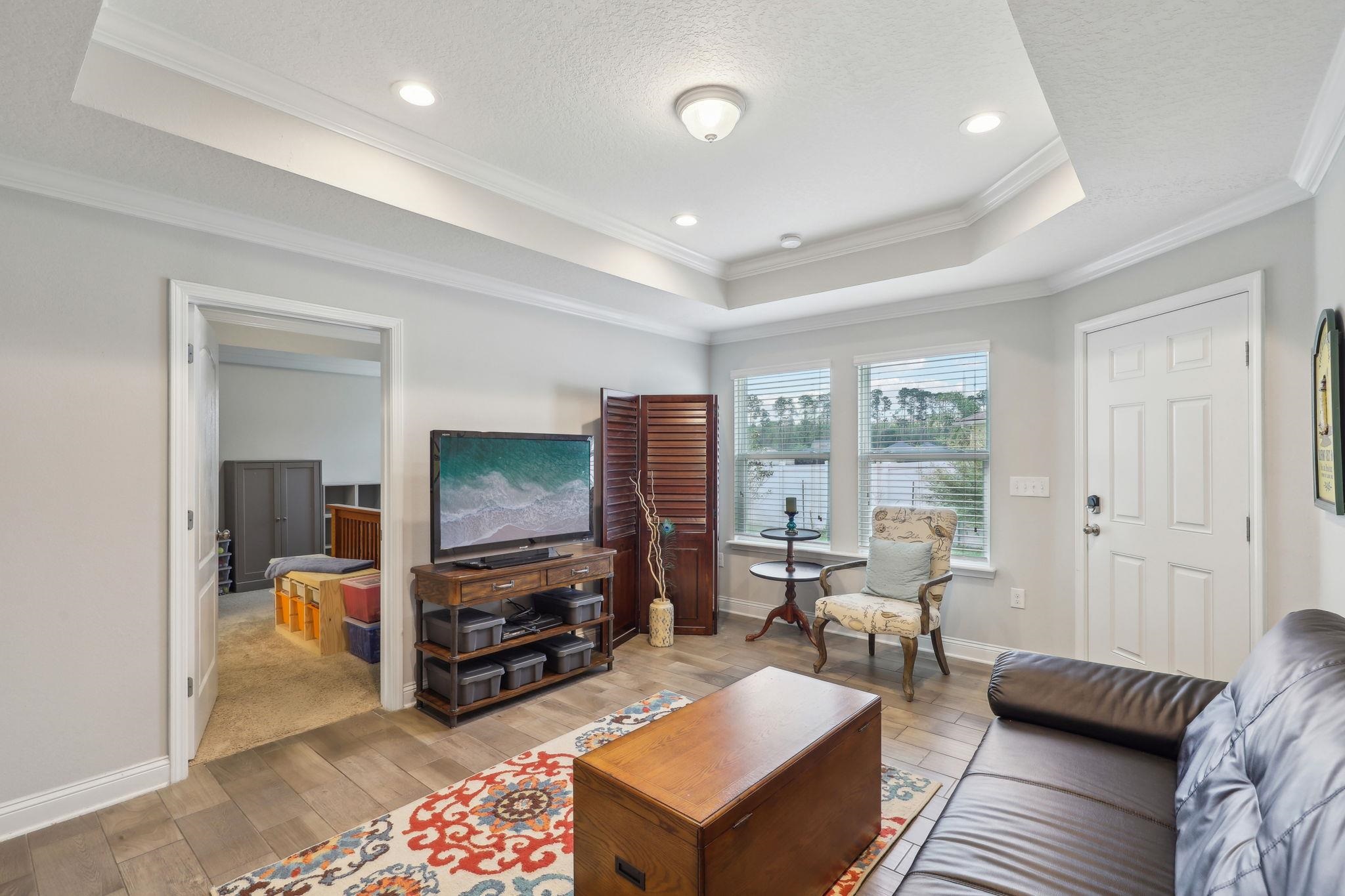 443 Sweet Mango Trail St. Augustine, FL 32086 - Photo 23 of 54 a living room with furniture and a flat screen tv