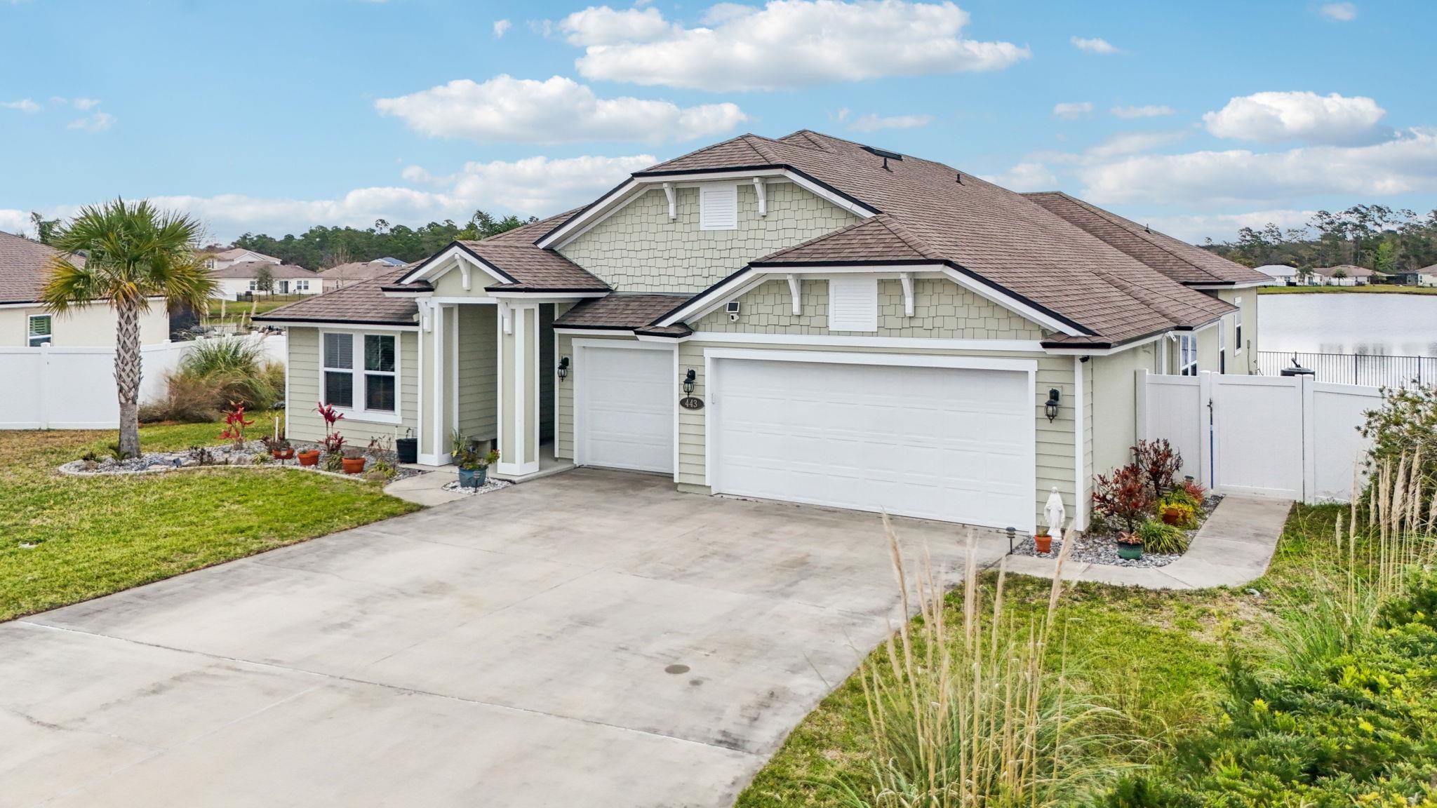 443 Sweet Mango Trail St. Augustine, FL 32086 - Photo 43 of 54 a front view of a house with garden
