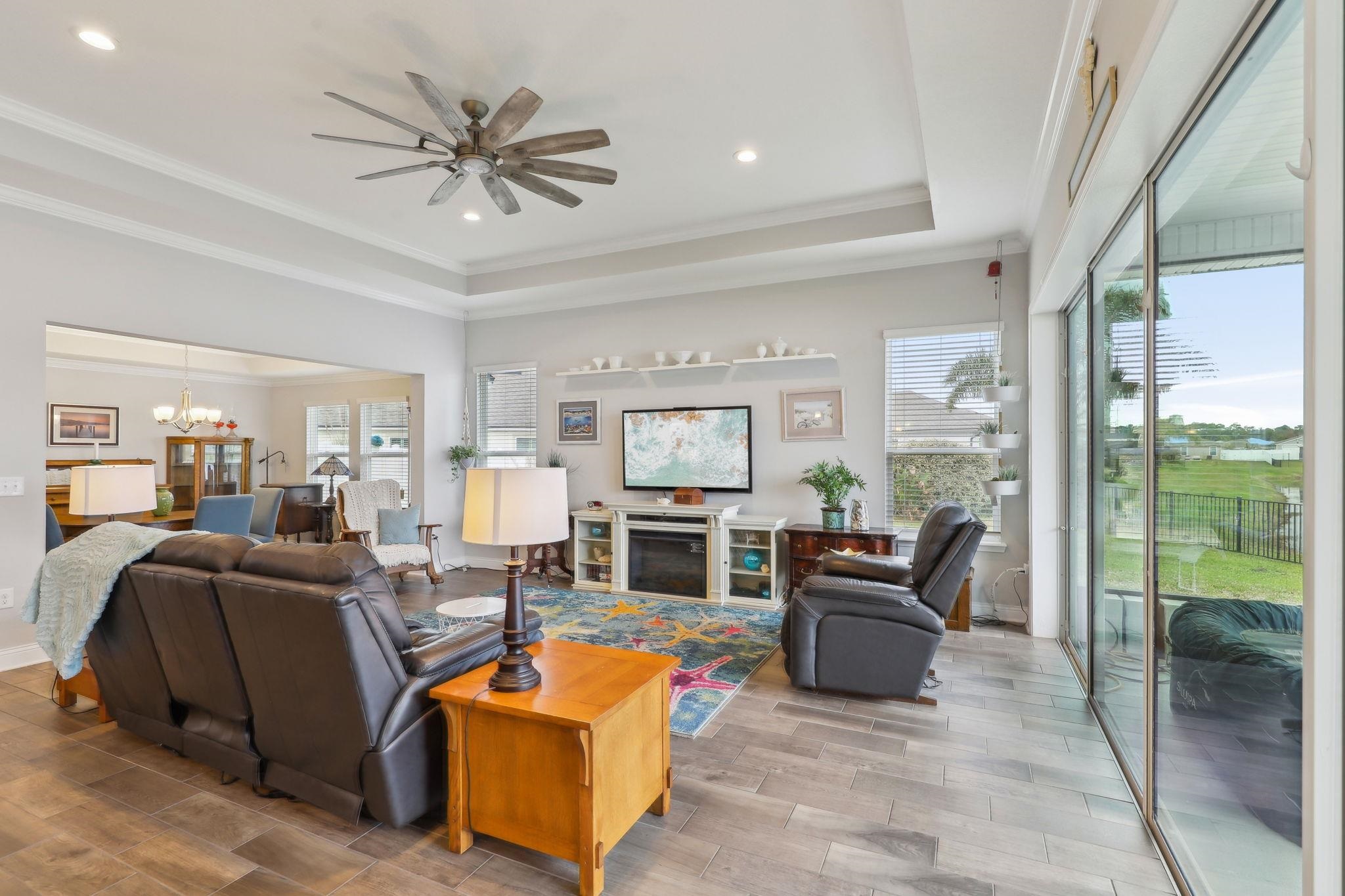 443 Sweet Mango Trail St. Augustine, FL 32086 - Photo 9 of 54 a living room with furniture a fireplace and a large window
