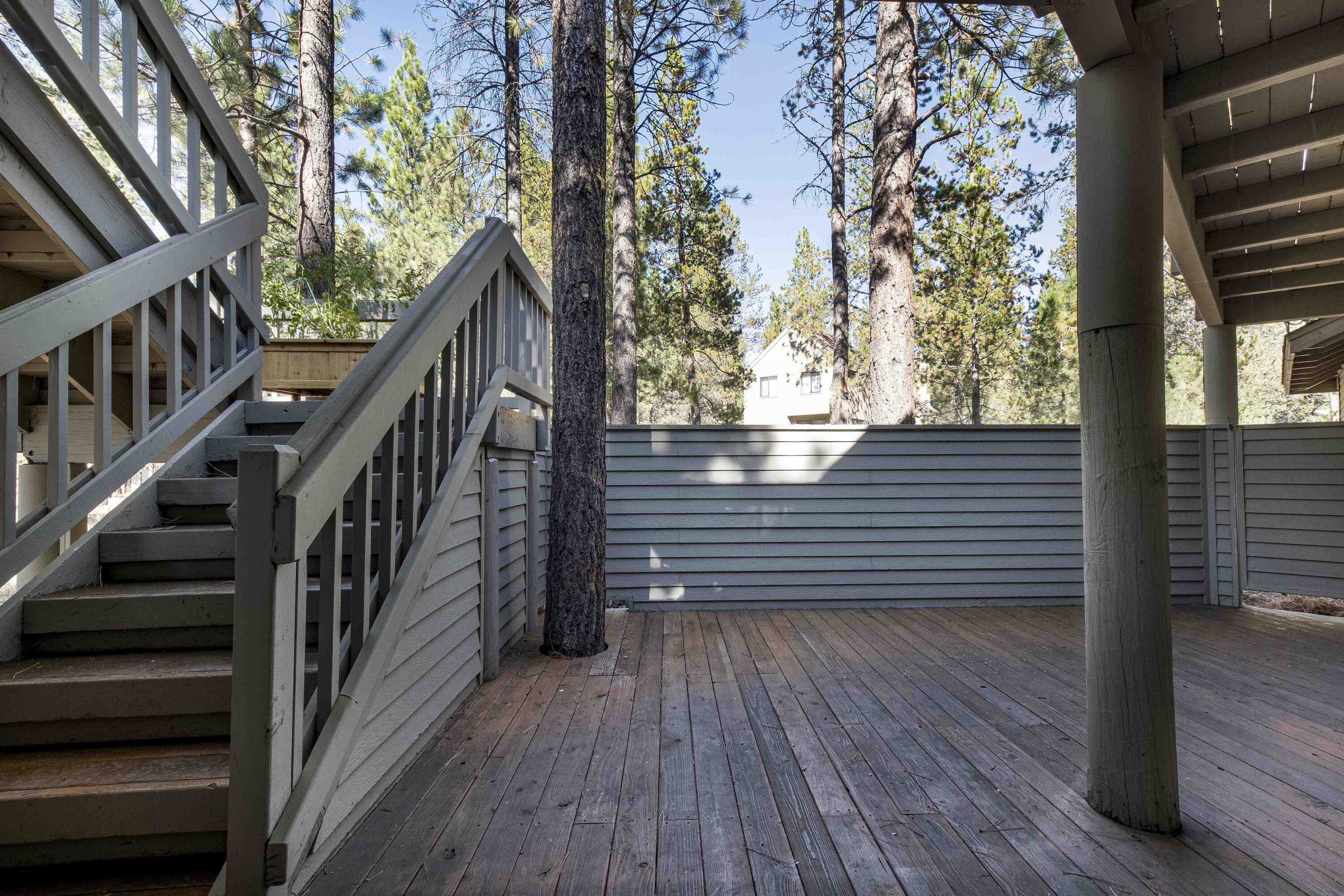 17912 Rhododendron Lane Sunriver, OR 97707 - Photo 24 of 35 Stairs from the upper deck, a door from bedroom #2 and a gate here offer access to the enclosed lower deck. This space is wired for a hot tub.