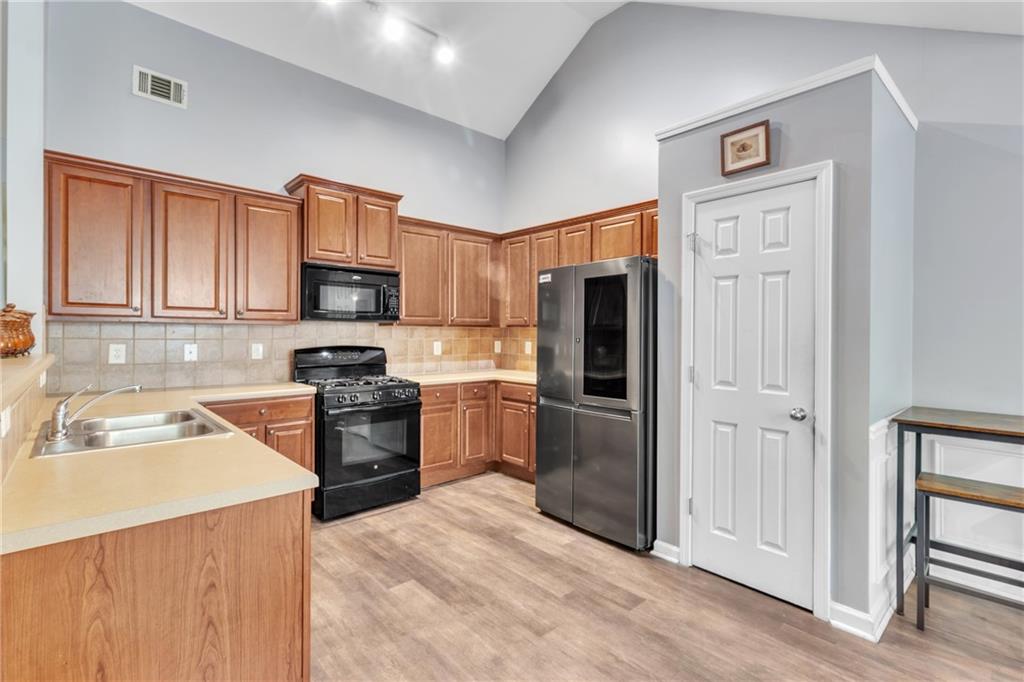 4044 Amberleigh Trace Gainesville, GA 30507 - Photo 6 of 22 a kitchen with granite countertop a refrigerator stove and sink