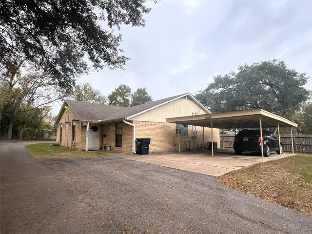 a view of a house with a yard and large tree