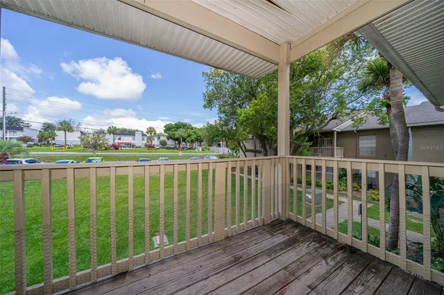 a view of a balcony with wooden floor & fence