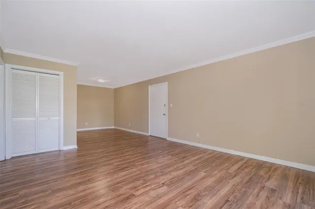 a view of an empty room with wooden floor