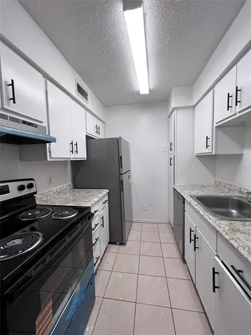 a kitchen with stainless steel appliances granite countertop a stove and a refrigerator