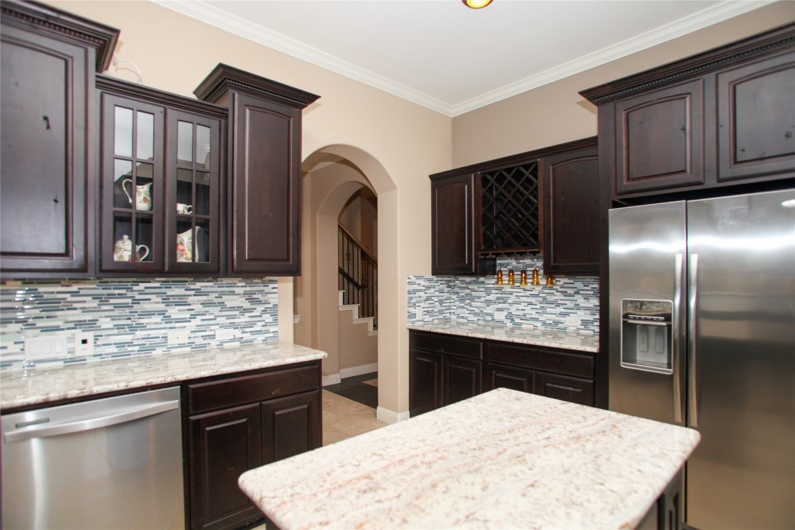 1589 Cool Spring Way Austin, TX 78737 - Photo 13 of 35 a kitchen with stainless steel appliances kitchen island granite countertop a refrigerator and stove
