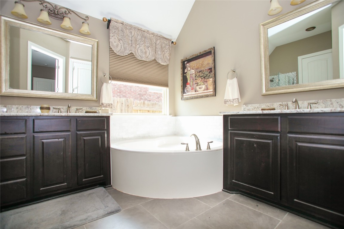 1589 Cool Spring Way Austin, TX 78737 - Photo 20 of 35 a bathroom with a tub a sink and mirror