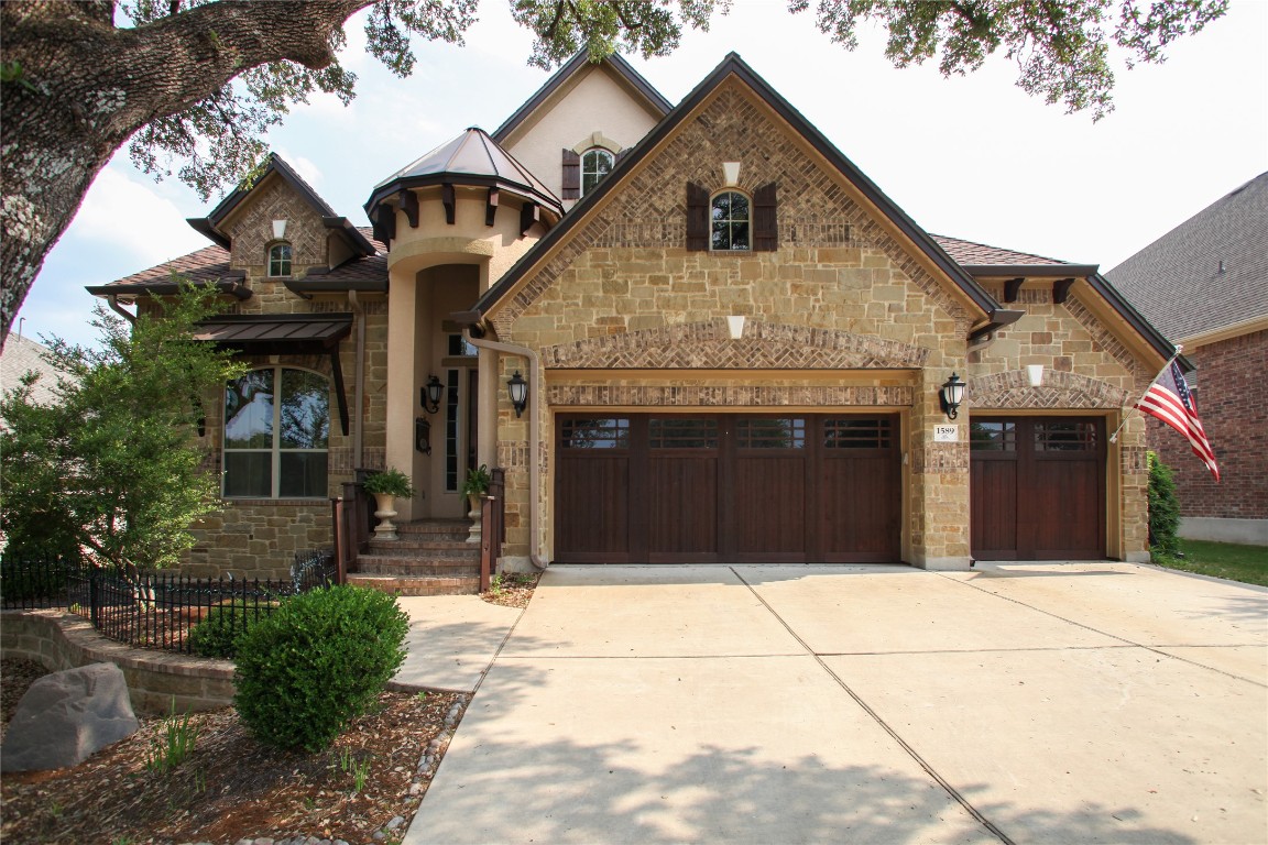 1589 Cool Spring Way Austin, TX 78737 - Photo 2 of 35 a front view of a house with a garage