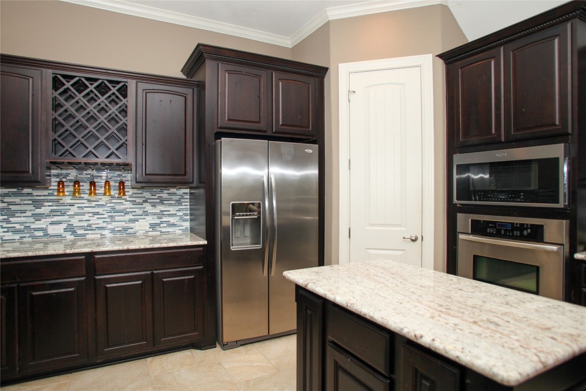 1589 Cool Spring Way Austin, TX 78737 - Photo 7 of 35 a kitchen with stainless steel appliances granite countertop a refrigerator and a stove top oven