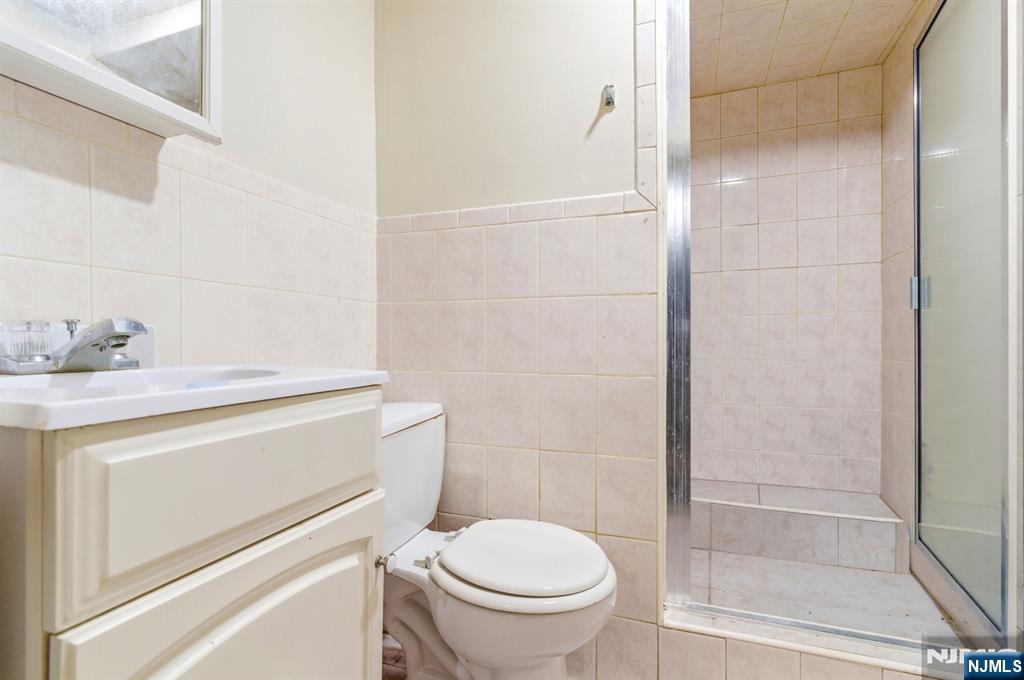 73-75 Knickerbocker Avenue Paterson, NJ 07503 - Photo 12 of 27 a bathroom with a sink a toilet and shower