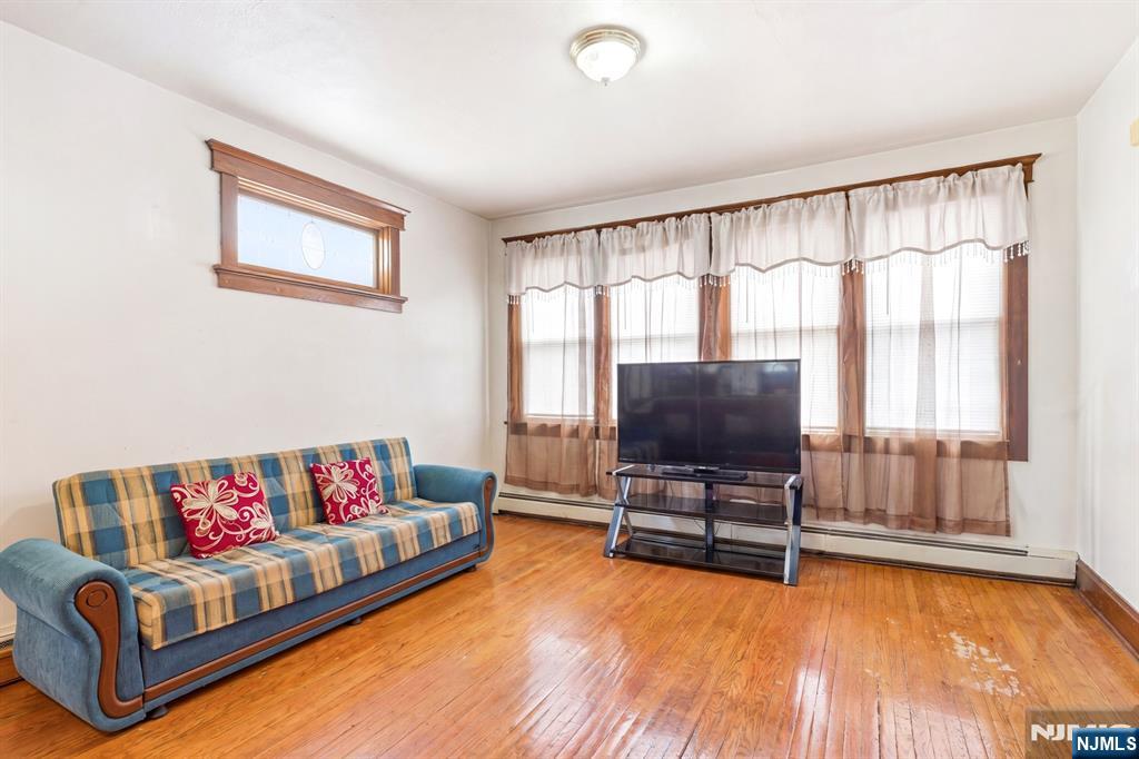 73-75 Knickerbocker Avenue Paterson, NJ 07503 - Photo 13 of 27 a living room with furniture and a flat screen tv