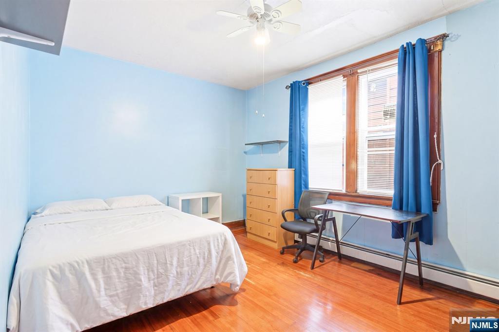 73-75 Knickerbocker Avenue Paterson, NJ 07503 - Photo 15 of 27 a bedroom with a bed a table and a large window