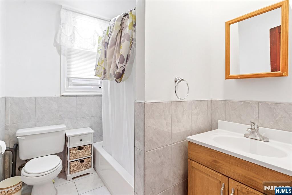 73-75 Knickerbocker Avenue Paterson, NJ 07503 - Photo 16 of 27 a bathroom with a sink a toilet and a mirror