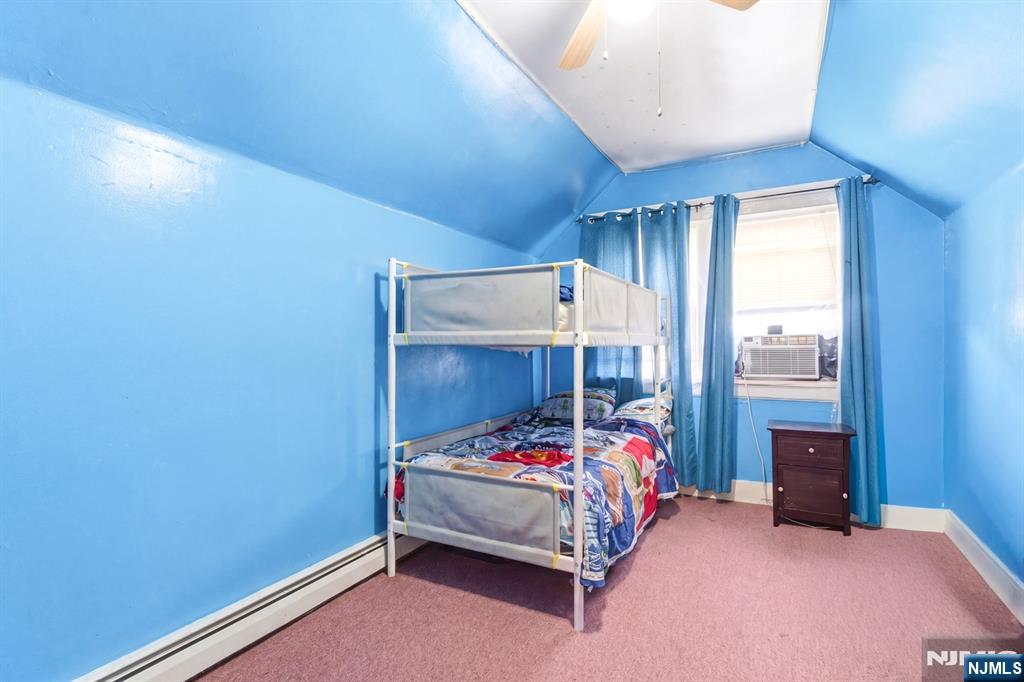 73-75 Knickerbocker Avenue Paterson, NJ 07503 - Photo 21 of 27 a bedroom with a bed a window and a table