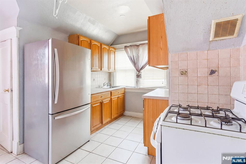 73-75 Knickerbocker Avenue Paterson, NJ 07503 - Photo 22 of 27 a kitchen with a refrigerator a stove top oven