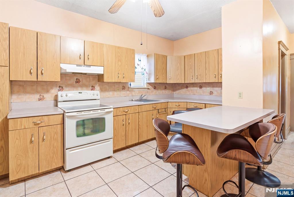 73-75 Knickerbocker Avenue Paterson, NJ 07503 - Photo 5 of 27 a kitchen with a stove a sink cabinets and a dining table