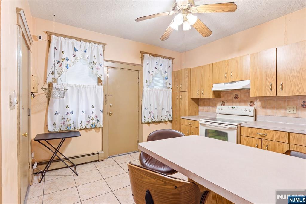 73-75 Knickerbocker Avenue Paterson, NJ 07503 - Photo 10 of 27 a kitchen with a table chairs refrigerator and cabinets