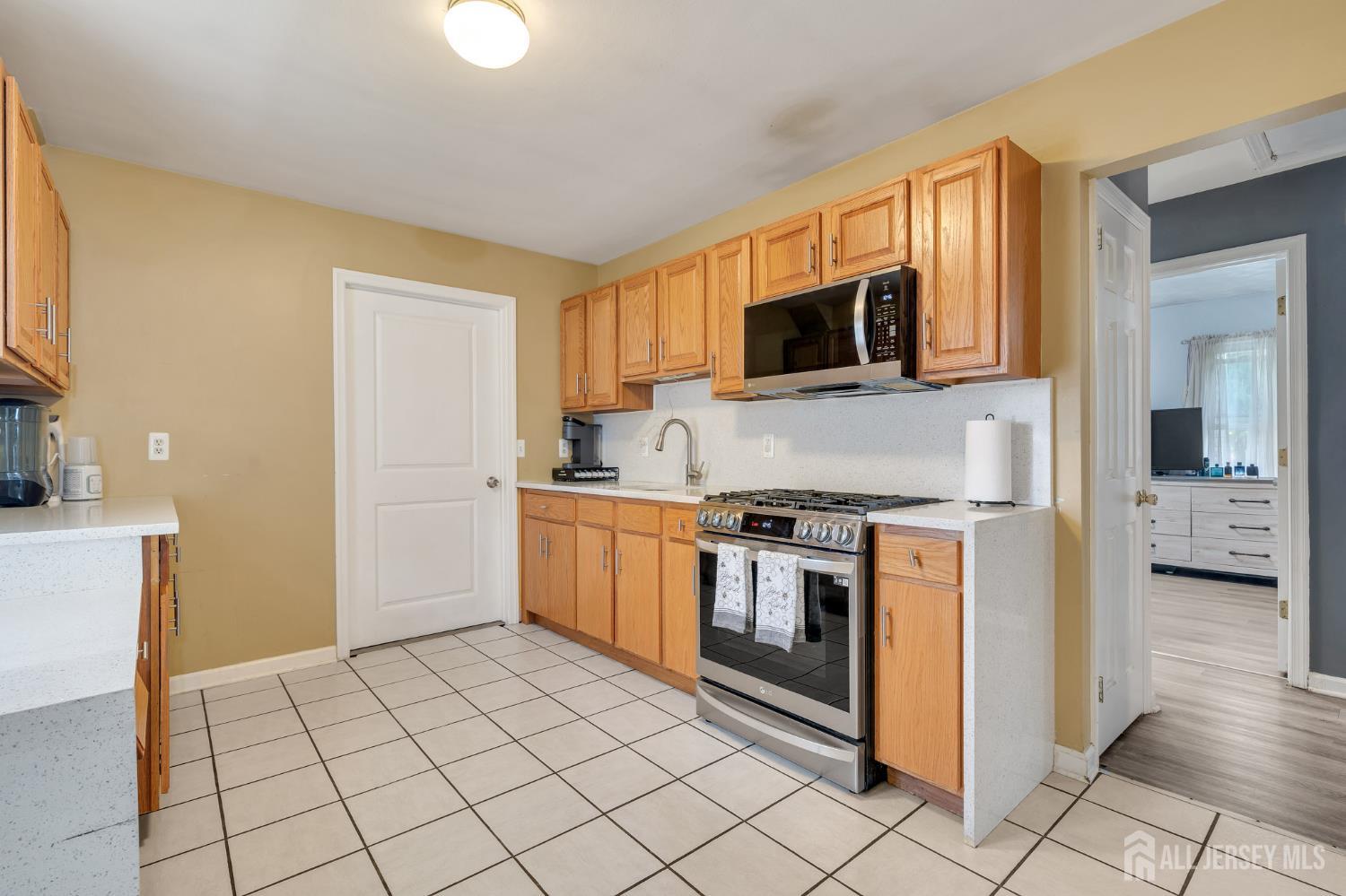 12 Pierrepont Avenue Middlesex, NJ 08846 - Photo 8 of 30 a kitchen with stainless steel appliances granite countertop a stove a sink and a microwave