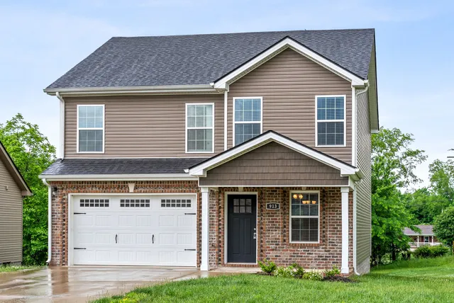 a view of a house with yard and garage
