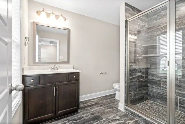 a bathroom with a shower sink and mirror