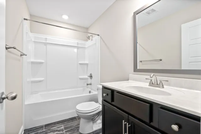 a bathroom with a sink a toilet a mirror and shower