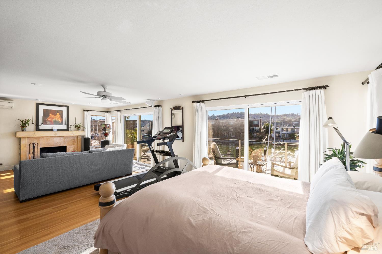 26 Mooring Road San Rafael, CA 94901 - Photo 36 of 60 The spacious primary bedroom looks out to the water and Mt. Tam and includes a lovely sitting area with a gas fireplace, built-in cabinetry, hardwood floors, a walk-in closet and ensuite bathroom. Sliding doors open out to a balcony perfect for enjoying the stunning views.