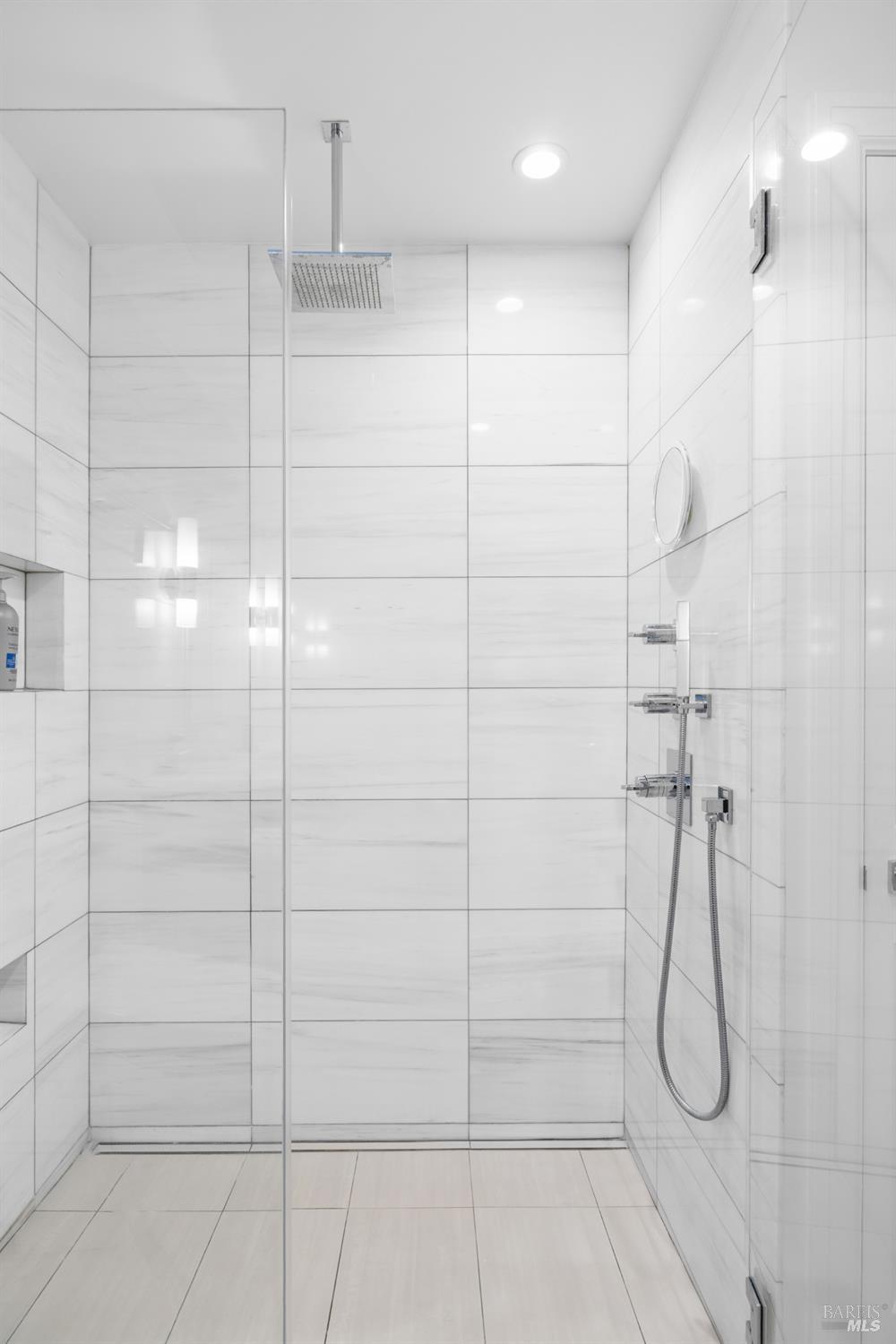 26 Mooring Road San Rafael, CA 94901 - Photo 51 of 60 The remodeled guest bath features a custom vanity, custom tile work, a walk-in shower with glass surround and a bidet toilet.