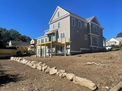 a front view of a house with a yard covered in snow