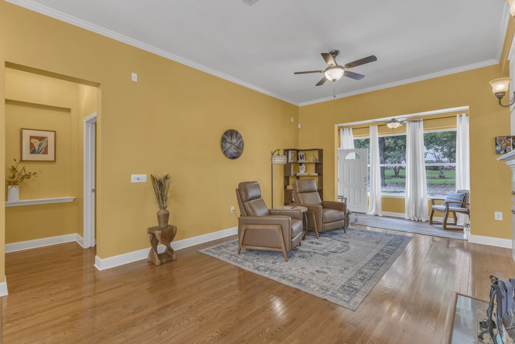 144 Cattle Trail Way Georgetown, TX 78633 - Photo 21 of 37 Hardwood floors stretch across this inviting living area, illuminated by natural light and overhead ceiling fans.