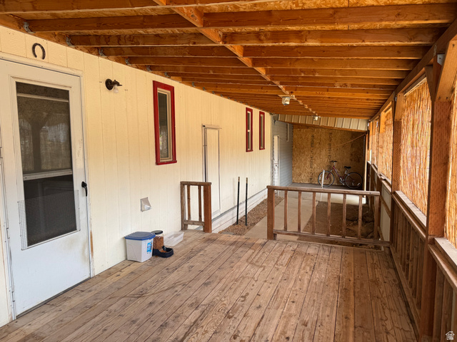 210 South State Street Moroni, UT 84646 - Photo 17 of 23 Expansive covered porch featuring wood-finish flooring, exposed wood beam ceiling, and a full-length screen door