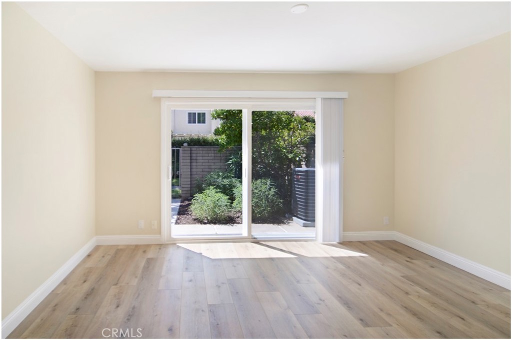 55 Oak Tree Lane Irvine, CA 92612 - Photo 13 of 27 an empty room with wooden floor and windows