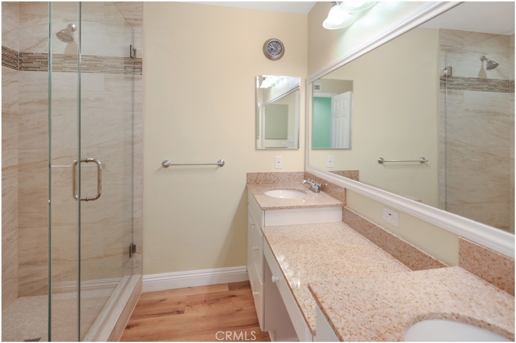 55 Oak Tree Lane Irvine, CA 92612 - Photo 16 of 27 a bathroom with a granite countertop sink a mirror and shower