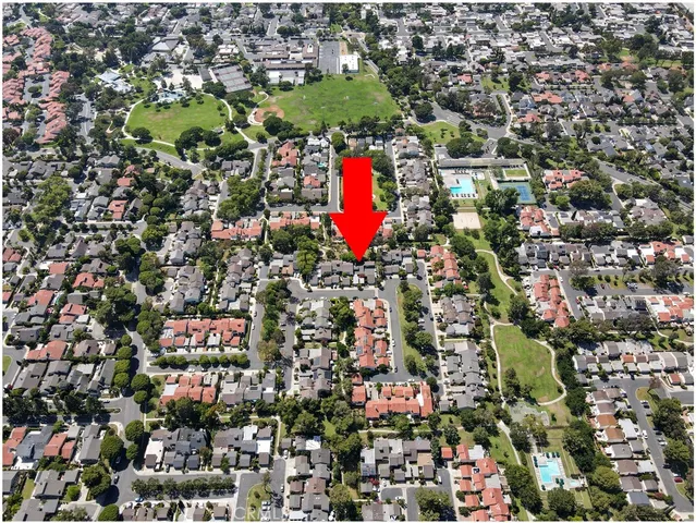 an aerial view of residential houses with outdoor space and covered by trees