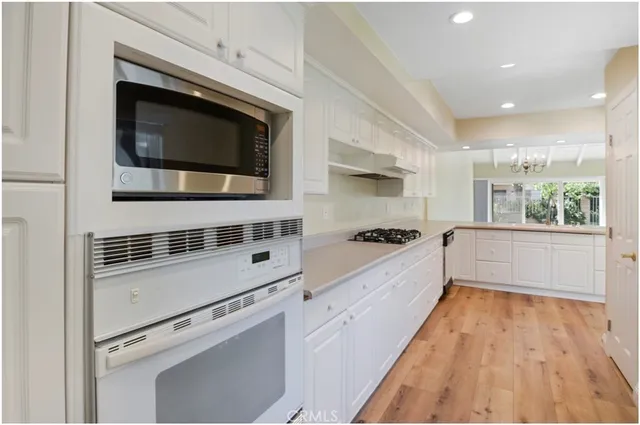 a kitchen with stainless steel appliances a stove microwave and cabinets