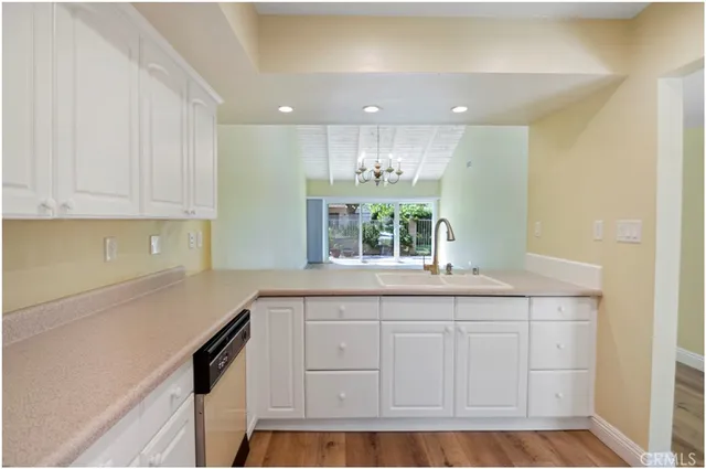 a kitchen with white cabinets and sink