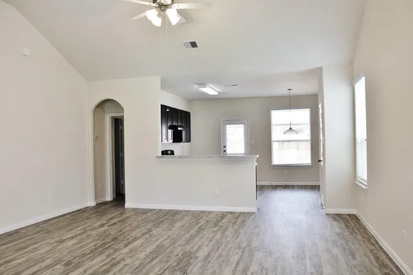a view of a big room with wooden floor and windows