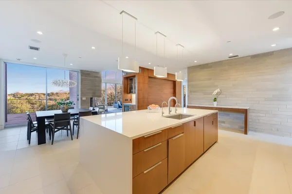 a large kitchen with a sink a counter top space and stainless steel appliances